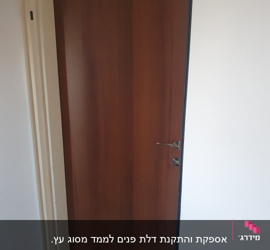 דלת עץ חומה עם ידית מתכת כסופה